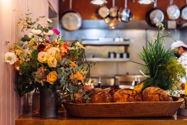 Basket of fresh bread and florals in front of the kitchen at Valley Restaurant